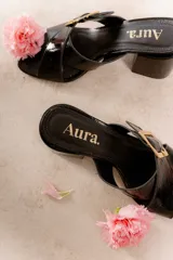 Sandalia color beige con tiras cruzadas y hebilla metálica cuadrada. Taco cuadrado de 6 cm.