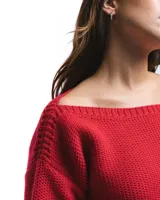 Sweater rojo de lana merino con cuello barco y motivo calado en el lateral.