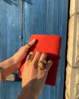 Anillo de diseño orgánico y macizo con forma irregular, elaborado en metal con acabado brillante. Presenta una estructura abierta que permite su ajuste.