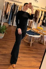 Conjunto de remera manga larga y pantalón palazo, de color negro con pequeños destellos brillantes distribuidos por toda la prenda.