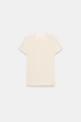 Camiseta de manga corta color marrón oscuro con textura acanalada, cuello redondo y bajo recto. Presenta un bajo superpuesto de tul o tela más clara, visible en el ruedo y en el cuello.