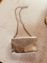 Cartera de fiesta plateada con solapa texturizada y cadena metálica.