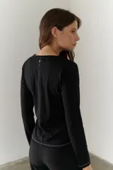 Remera blanca de algodón grueso con cuello redondo y mangas largas.