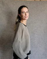 Buzo tostado de corte holgado con cuello redondo y manga larga. Presenta una estrella blanca estampada en la espalda y ribete marrón en cuello y ruedo.