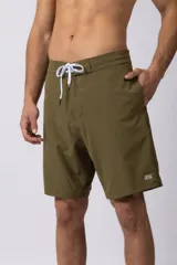 Short de baño de corte moderno y limpio, color verde militar. Presenta cintura elástica con cordón de ajuste blanco, bolsillos laterales y una pequeña etiqueta con el logo de la marca en el ruedo inferior.