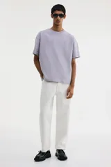 Remera de punto de algodón pesado, color lila claro, con cuello redondo ribeteado, hombros caídos y bajo recto. Corte holgado.