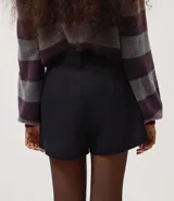Short sastrero de color negro, con cintura fija, presillas para cinturón, cierre frontal tradicional y bolsillos laterales.