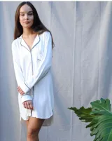 Camisa blanca de algodón con vivos negros, de manga larga y largo arriba de la rodilla.