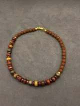 Collar artesanal corto con cuentas de piedras naturales facetadas en tonos tierra, marrones y verdes.