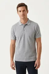 Remera polo de manga corta en color gris melange, confeccionada en tejido de algodón. Presenta cuello camisero y cierre frontal de tres botones.