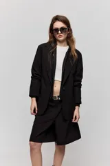 Blazer sastrero negro de calce relajado, con solapa clásica, cierre de un botón frontal y bolsillos laterales con tapa.