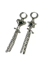 Aros colgantes asimétricos de acero quirúrgico. Un aro cuenta con un dije de estrella y un colgante en forma de púa, mientras que el otro presenta un dije de estrella acompañado de múltiples cadenas colgantes.