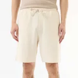 Bermuda blanca de felpa ligera con bolsillos laterales y cintura elástica con cordón ajustable.
