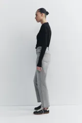 Jeans de tiro alto color negro con efecto lavado, corte mom fit, cinco bolsillos y cierre frontal con cremallera y botón metálico.