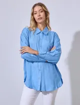 Camisa amarilla con bordado floral, cuello con solapa, abertura central con botones y bolsillo aplicado en el pecho.