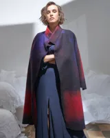 Tapado largo de lana merino afieltrada color rojo y violeta con diseño degradado. Tiene bolsillos laterales y puede usarse suelto o cruzado.