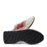 Championes urbanos New Balance modelo U370, con diseño en tonos beige, gris y detalles en rojo. Presentan una combinación de malla y gamuza, con el logo 'N' característico en los laterales y una suela de doble tono.