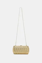 Bolso tipo clutch rígido con diseño trenzado y acabado metalizado dorado. Cuenta con cierre imantado y correa de cadena metálica fina para usar como bandolera.