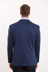 Saco azul oscuro de corte entallado, con solapa de muesca, cierre de dos botones, bolsillo de ribete en el pecho y bolsillos de parche en los laterales.