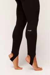 Calza legging de tiro alto color negro, confeccionada en tejido técnico de poliamida y elastano. Presenta un diseño minimalista con ajuste al pie mediante tira elástica (estribo).