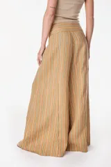 Pantalón de lino pernera ancha, con diseño a rayas en tonos tostado, verde y blanco, y pretina alta.