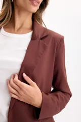 Blazer sastrero de lino color marrón, de líneas clásicas con solapas, bolsillos delanteros con solapa y caída liviana.