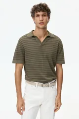 Polo de punto suave color verde militar con diseño a rayas horizontales oscuras, cuello camisero con escote en V y mangas cortas.