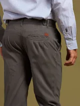 Pantalón de vestir color beige con pinzas, bolsillos laterales y traseros. El ruedo tiene un pequeño corte lateral.