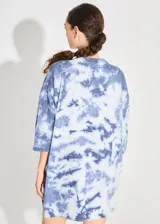 Sweater de punto tipo remerón oversize con diseño batik artesanal en tonos azul y blanco. Presenta silueta amplia, manga caída y etiqueta tejida con monograma en el frente.