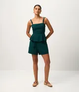 Short corto en viscolino verde oscuro, con cintura elástica, cordón ajustable con detalle de nudos y dobladillo pespuntado.