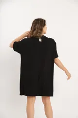 Vestido corto negro de corte holgado y mangas cortas. Tejido de punto acanalado.