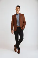 Blazer de pana color marrón oscuro, con cierre frontal de dos botones, solapas clásicas y bolsillos laterales con solapa. Presenta un diseño estructurado y elegante.