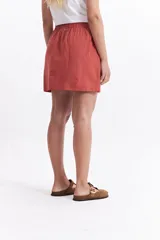Falda corta de color negro, confeccionada en algodón liviano. Presenta una cintura elastizada con lazo ajustable y bolsillos laterales.
