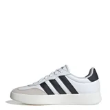 Championes urbanos Adidas modelo Barreda, de diseño inspirado en el tenis con puntera en T. Presentan una combinación de cuero sintético blanco con refuerzos de gamuza gris en la puntera y las icónicas tres tiras laterales en negro. Cuentan con suela cupsole de goma y cierre mediante cordones.