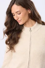 Campera tejida de abrigo color beige, con cierre frontal, cuello alto y bolsillos laterales.