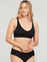 Bralette negro de diseño minimalista, sin aros, con copas suaves y pads removibles. Presenta tiras regulables y espalda en U, ofreciendo un ajuste cómodo y acabado invisible.