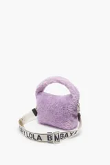 Bolso bandolera tipo hobo pequeño, color lila, de pelo sintético. Tiene cierre de cremallera, asa corta y asa bandolera extraíble con logo.