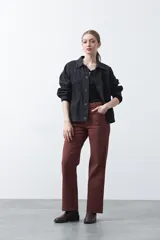 Pantalón ancho de tiro alto y corte recto, color marfil, con bolsillos frontales aplicados y cierre de doble botón metálico.