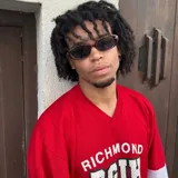 Lentes de sol con armazón ovalado de estilo retro en color negro y cristales oscuros. Presentan un detalle metálico en forma de estrella en las patillas.