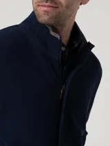 Buzo de hombre con cierre frontal completo y tapeta, cuello alto con terminación en contraste, manga larga y bolsillos laterales. Confeccionado en tejido de algodón orgánico y poliéster reciclado.