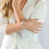 Pulsera plateada con eslabones circulares calados con forma de rosa.