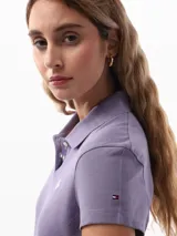 Chomba color lila de corte slim confeccionada en tejido de piqué suave y transpirable. Presenta cuello tipo chomba, cartera de dos botones, logo de Tommy Hilfiger bordado en el pecho y bandera de Tommy Hilfiger bordada en la manga.