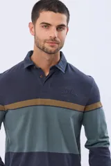 Remera polo de manga larga con diseño de bloques de color horizontales en tonos azul, verde y marrón. Presenta cuello clásico, cierre frontal con botones y bordado en el pecho. Cuenta con puños elásticos acanalados.