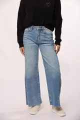 Pantalón de jean estilo wide leg con tiro alto, diseño de costuras diagonales en el frente y ruedo deshilachado.