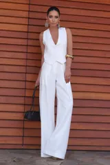 Pantalón de vestir blanco de corte recto y tiro alto, con pinzas delanteras, hebilla en la cintura y bolsillos laterales.