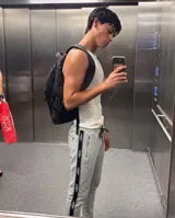 Pantalón de jogging gris melange con cinta lateral negra personalizada con logo, bolsillos con cierre y puños elastizados.