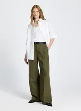 Musculosa blanca de punto con escote redondo, tirantes anchos y detalle de botones decorativos en el frente.