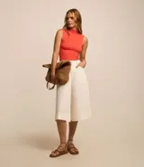 Blusa sin mangas de calce ajustado, confeccionada en tejido de viscosa con textura acanalada y cuello alto.