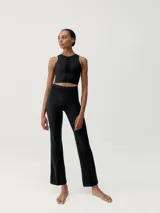 Legging flare largo de color negro, confeccionado en tejido Skin_Move. Presenta cinturilla ancha de doble tejido y un panel decorativo de malla transpirable en el centro del torso.