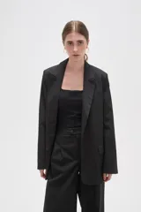 Blazer de corte holgado con diseño de rayas verticales, cuello solapa y cierre frontal con un botón. Cuenta con bolsillos laterales con solapa.